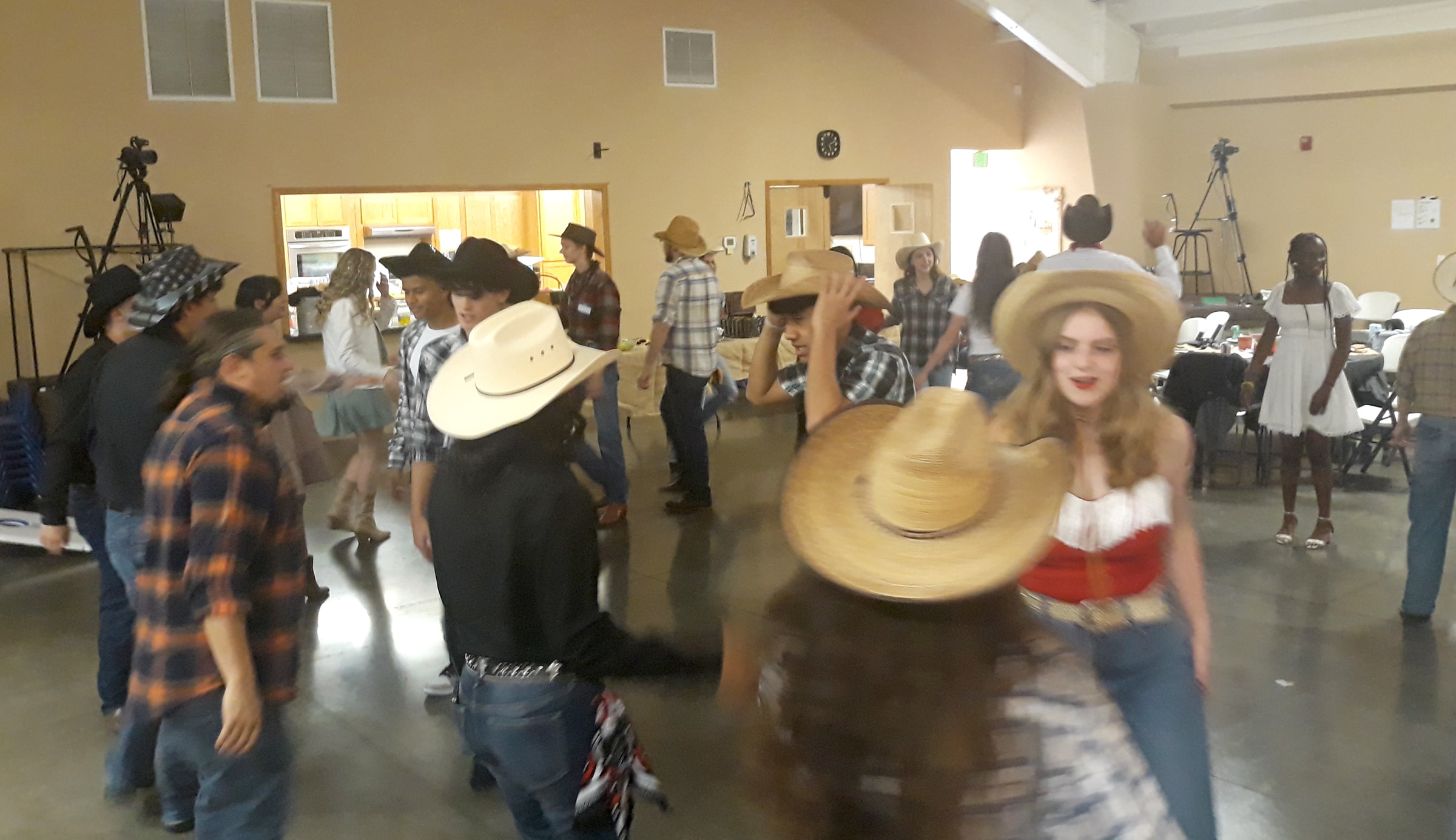 Teenagers in cowboy hats enjoying a lively barn dance party in Grants Pass, Oregon