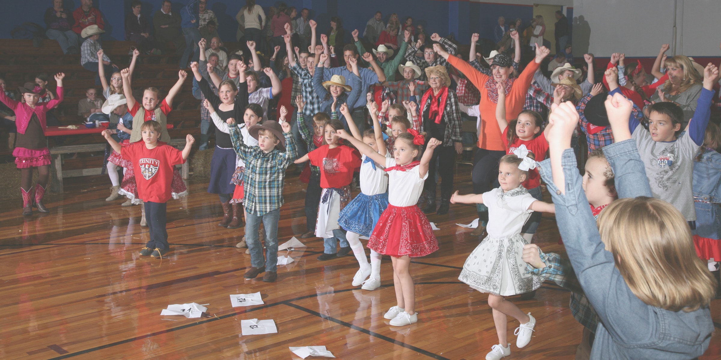 Children wearing cowboy hats at school dance event